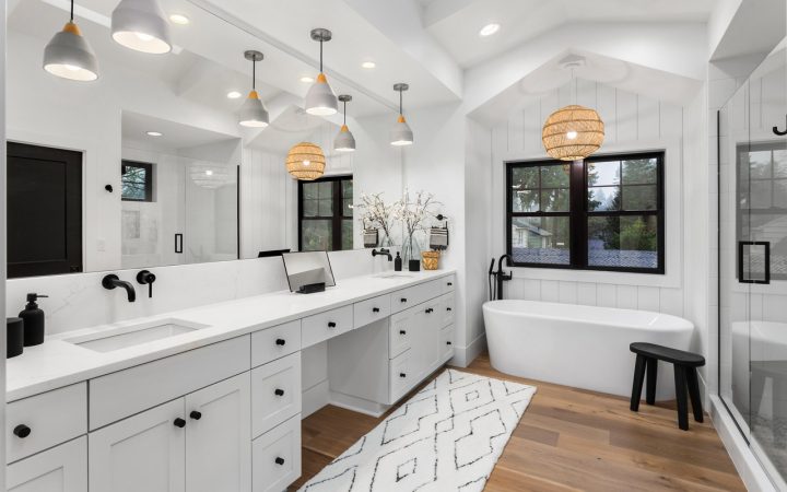 Modern and spacious bathroom featuring a freestanding tub, long vanity with double sinks, and unique pendant lighting, providing a stylish bath experience.
